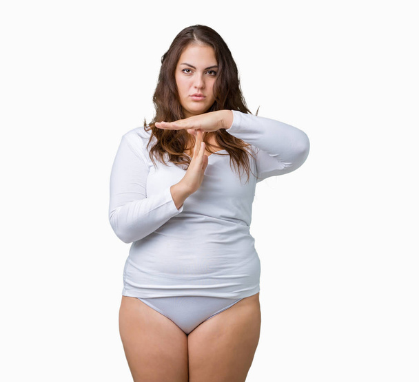 Beautiful plus size young overwight woman wearing white underwear over isolated background Doing time out gesture with hands, frustrated and serious face - Photo, Image