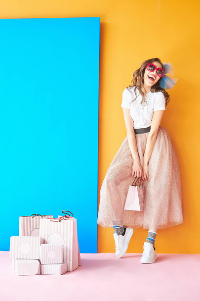 Colorful portrait of happy confectioner woman in white shirt and pink glitter skirt. Candy colors. - Foto, afbeelding