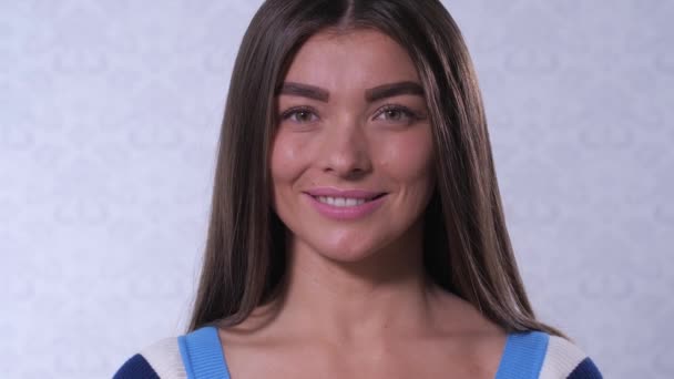 A girl with beautiful wide eyebrows looks in a frame and smiles. 4K Slow Mo - Кадри, відео