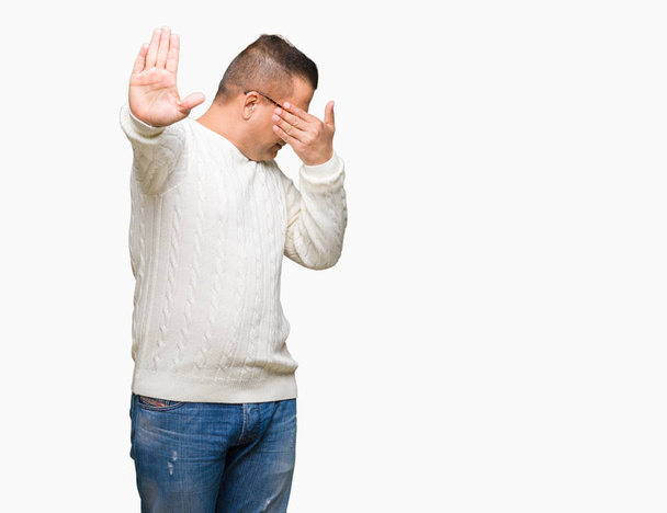 Uomo arabo di mezza età che indossa occhiali su sfondo isolato coprendo gli occhi con le mani e facendo fermare il gesto con espressione triste e paura. Concetto imbarazzato e negativo
. - Foto, immagini