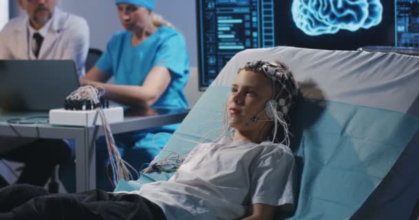 Niño acostado en la cama durante el examen EEG
 - Metraje, vídeo