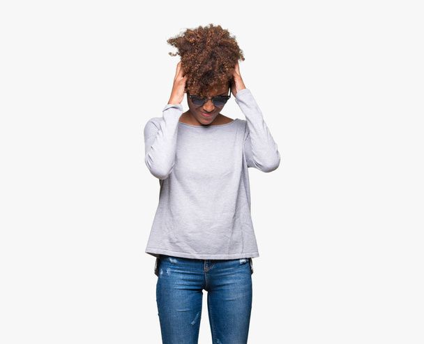 schöne junge afrikanisch-amerikanische Frau mit Sonnenbrille über isoliertem Hintergrund leidet unter Kopfschmerzen verzweifelt und gestresst, weil Schmerzen und Migräne. Hände auf den Kopf. - Foto, Bild