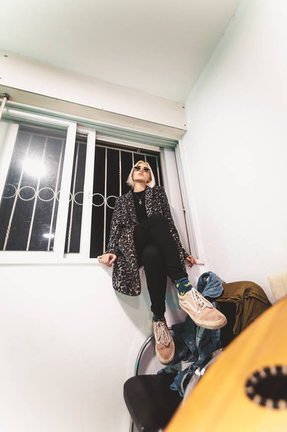 Sarışın hipster genç kadın pencere eşik üzerinde poz - Fotoğraf, Görsel