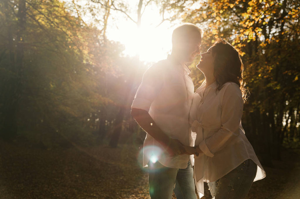 Romantic young couple walking in autumn park. Family together in the park. Pregnant couple. - Zdjęcie, obraz