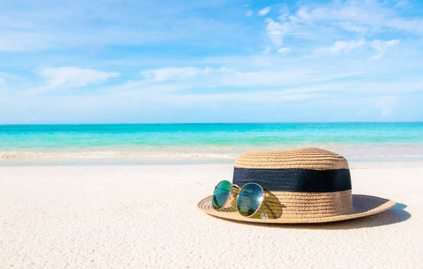 Sombreros y gafas colocados en la playa y el mar tienen un verano de vacaciones relajante y viajar brillante cielo koh lipe tailandia
 - Foto, imagen