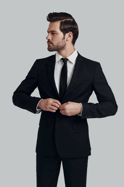 Young and successful. Handsome young man in full suit adjusting  - Photo, Image