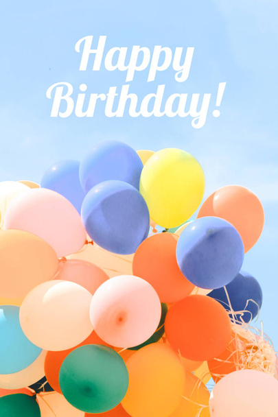 happy birthday lettering and colorful balloons in blue cloudy sky - Photo, Image