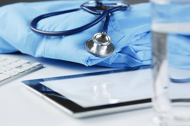 Image du stéthoscope et du manteau du médecin sur la table dans une salle de consultation. Concept médical - Photo, image