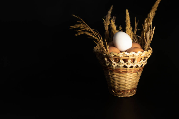 Φυσικά αυγά κοτόπουλου σε ένα ψάθινο καλάθι στο τραπέζι. - Φωτογραφία, εικόνα