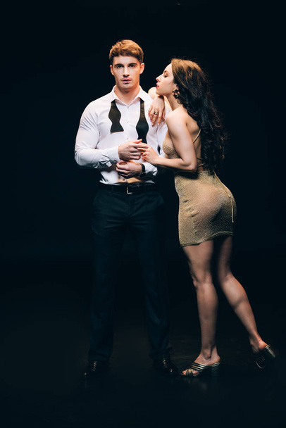 sexy elegant young couple isolated on black - 写真・画像