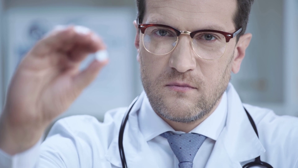 magabiztos orvos a szemüveg bemutató tablettát, miközben nézi kamera - Felvétel, videó
