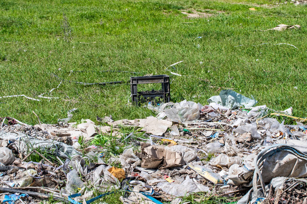 Пластиковые отходы мусора на зеленой траве, загрязнение окружающей среды
. - Фото, изображение