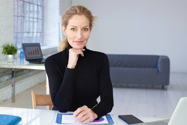 Attractive blond businesswoman sitting in the office  - Fotografie, Obrázek