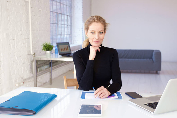 Attractive blond businesswoman sitting in the office  - Foto, Bild