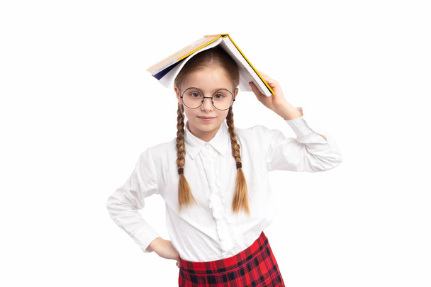 Schoolgirl with textbook on head - Zdjęcie, obraz