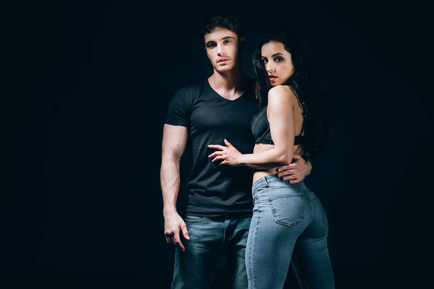 young couple in denim hugging isolated on black  - Photo, Image