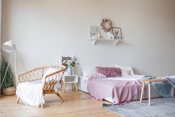 Real photo of the bright cozy bedroom interior with panoramic window. King size bed on the wooden floor, gray carpet, white wall with eco-themed posters . Wicker chair in front of the window. - 写真・画像