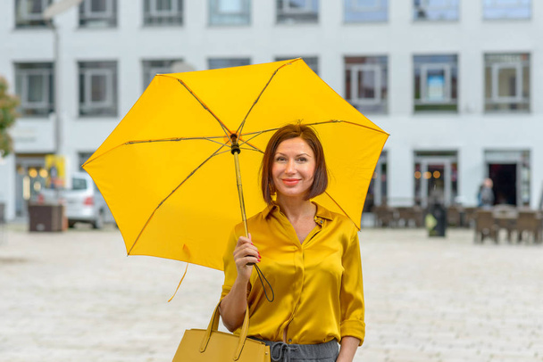 Елегантна жінка в жовтому ансамблі в місті
 - Фото, зображення