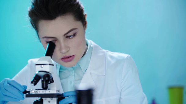 pretty, attentive scientists making research with microscope in laboratory - Video, Çekim