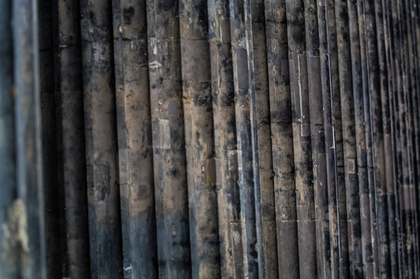 Background or texture from a concrete dark column with strips and deepenings. - Foto, imagen