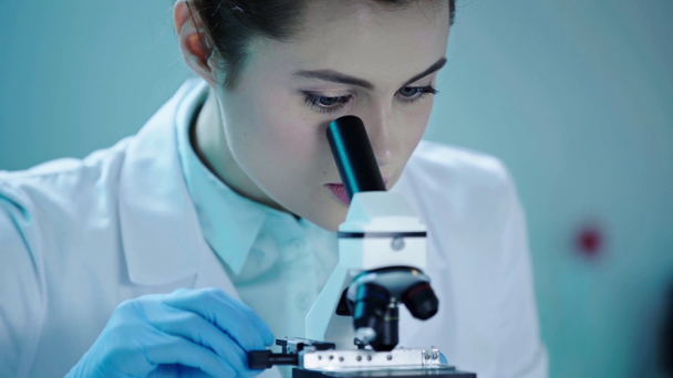όμορφη επιστήμονας μιλάει, ενώ κάνει ανάλυση με μικροσκόπιο στο εργαστήριο - Πλάνα, βίντεο