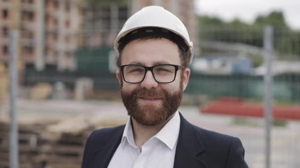 Portrait of construction worker on building site smiling at the camera. - Felvétel, videó