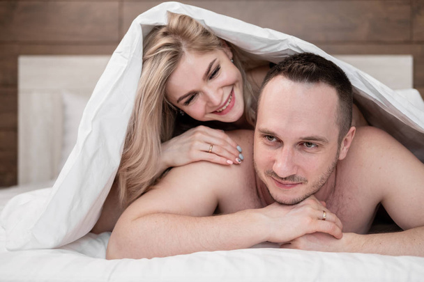 Una coppia sposata, un uomo e una donna, sono sdraiati a letto, abbracciati e dormono
. - Foto, immagini