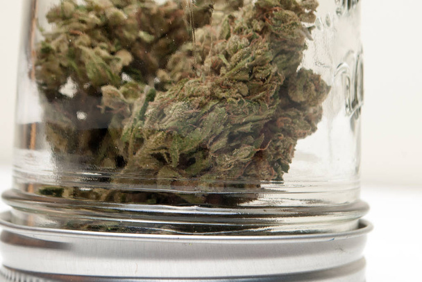 Close up view of dried marijuana in glass jar. Drug addiction concept. Medical marijuana concept  - Foto, Bild