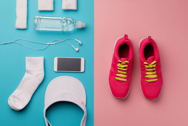 A studio shot of running shoes and other sport equipment on color background. - Фото, изображение