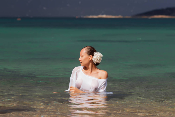 Femme en chemisier humide debout dans l'eau
 - Photo, image