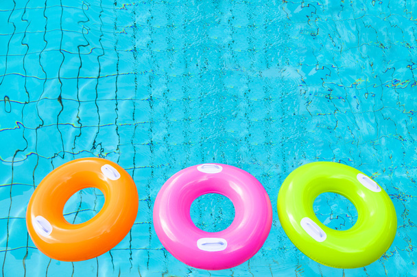 three colorful swimming pool rings on the water - Photo, Image