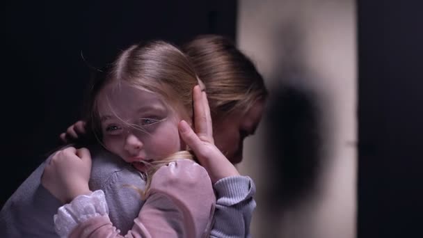Chica asustada abrazando a la madre, terrible silueta criminal masculina fuera de la puerta
 - Metraje, vídeo
