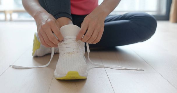 Woman wearing sport shoes at home - Foto, Bild