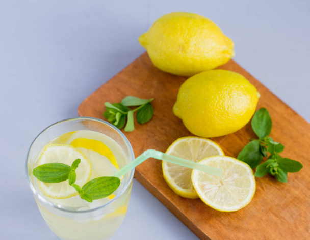 вода в стакане с лимоном и листьями орегано, освежающий прохладительный напиток, чтобы утолить жажду в жару и поддерживать тонус
 - Фото, изображение