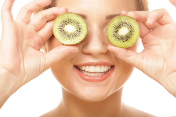 Funny woman holding kiwi fruit for her eyes. - Foto, immagini