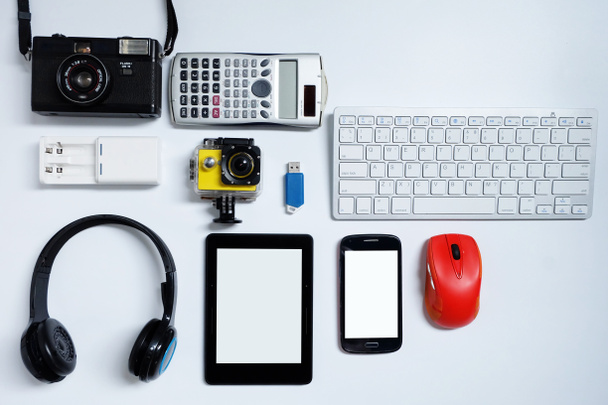 携帯電話、カメラ、キーボード、マウス、フラッシュドライブUSBを備えた電子書籍リーダー。白い背景に、 日常的な使用の概念のための使用された現代のガジェットや電子機器, トップビュー - 写真・画像
