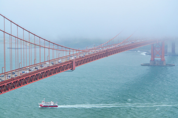 Closeup view of Golden Gate Bridge from Marin Headlands with a boat passing underneath in San Francisco, California - Photo, Image