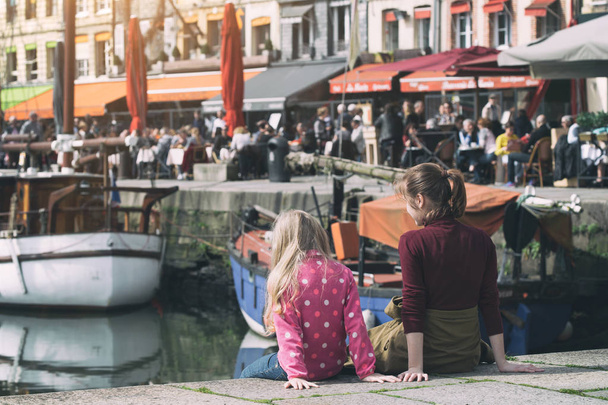 Mädchen sitzen auf Hintergrund berühmten französischen Stadt honfleur  - Foto, Bild