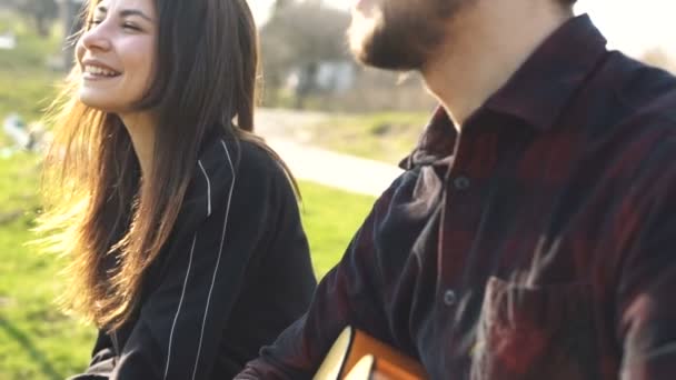 Ember játssza a gitárt a barátnője. Szabadtéri. Romantikus - Felvétel, videó