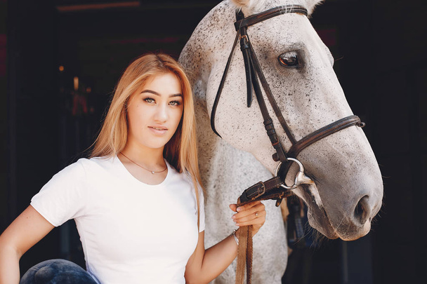Elegant girl in a farm wiith a horse - Foto, imagen