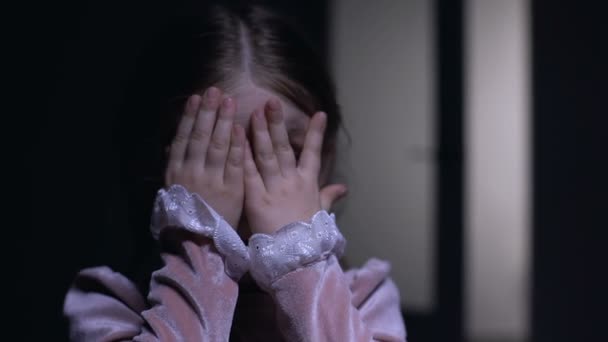 Bang vrouwelijk kind gluren door vingers bij camera, fobie en angst concept - Video