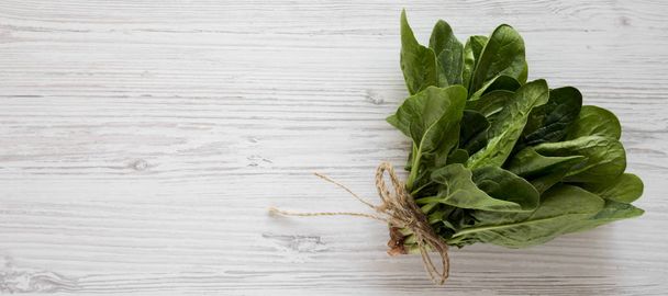 Overhead view, fresh raw spinach on a white wooden background. F - 写真・画像