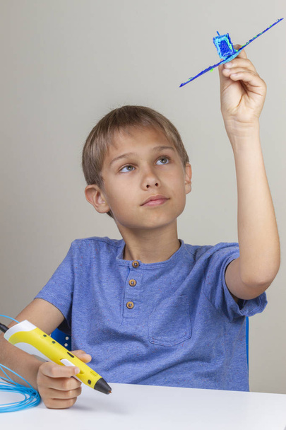 Kid creating with 3d printing pen and enjoy his new blue plane - Fotoğraf, Görsel