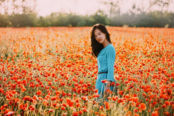 Zomer mooi meisje wandelen in rode Poppy bloem veld.  - Foto, afbeelding
