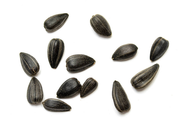 Чорне насіння соняшнику на білому тлі
. - Фото, зображення