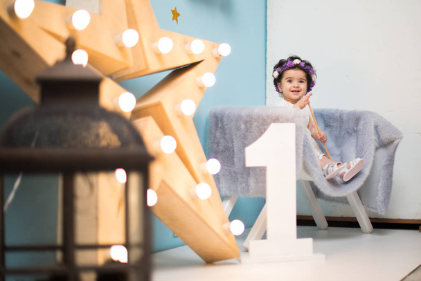 glücklich lächelnd süßes Baby Mädchen sitzt auf Sessel mit leuchtenden l - Foto, Bild
