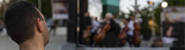 Música clásica en el concierto al aire libre. La gente toca instrumentos musicales. Escuchando música
. - Foto, imagen