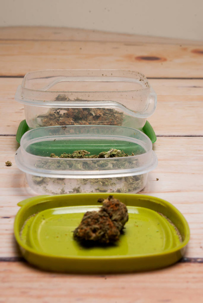 Close-up weergave van gedroogde marihuana in plastic containers. Drugsverslaving concept. Medisch marihuana concept  - Foto, afbeelding