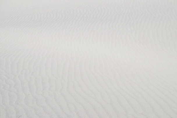 Sumentunut aaltoileva valkoinen hiekka rakenne
 - Valokuva, kuva