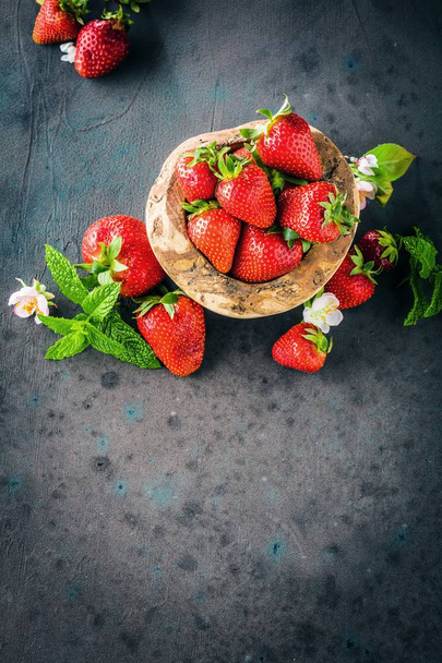 top view of fresh ripe strawberries and flowers on grey background - Foto, Imagem